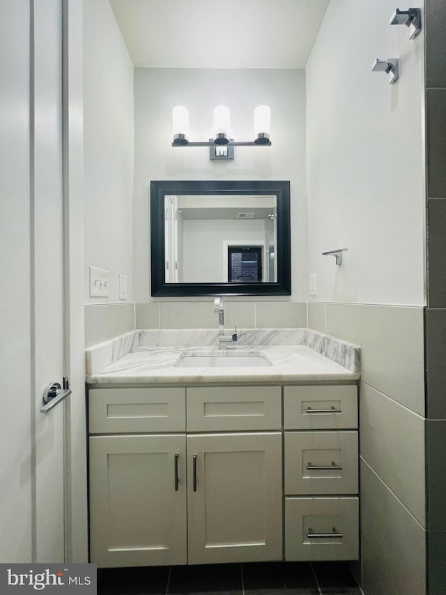 bathroom featuring tile patterned flooring, vanity, and tile walls