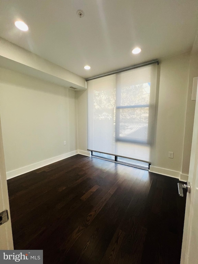 spare room featuring hardwood / wood-style floors and a baseboard heating unit