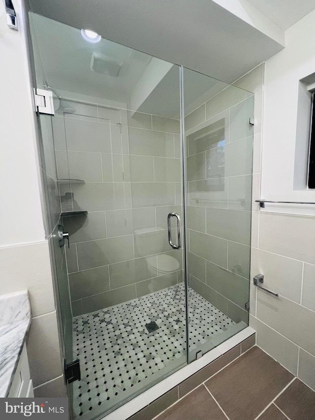 bathroom featuring tile patterned floors, toilet, vanity, and walk in shower