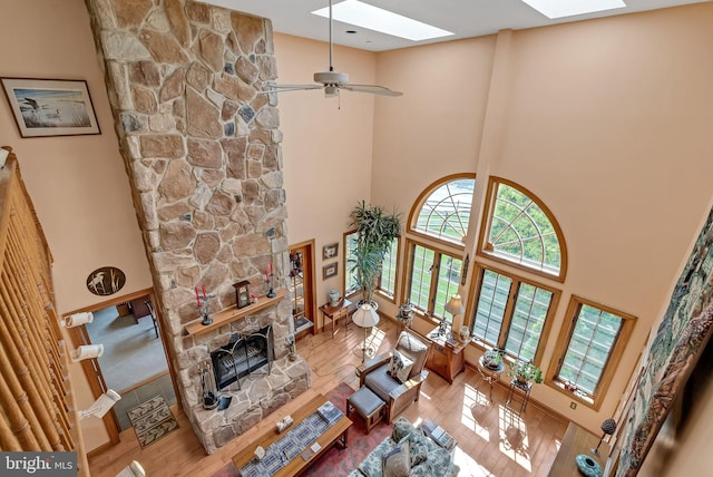 living room with a fireplace, a towering ceiling, and hardwood / wood-style flooring