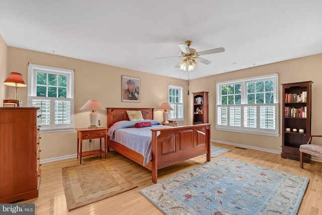 bedroom featuring multiple windows, ceiling fan, and light wood-type flooring