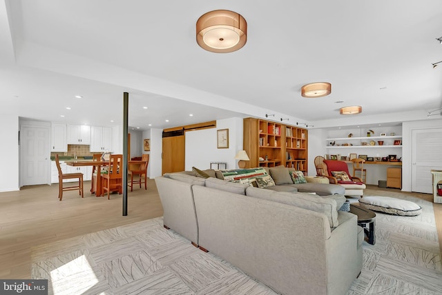 living room featuring a barn door and light hardwood / wood-style floors