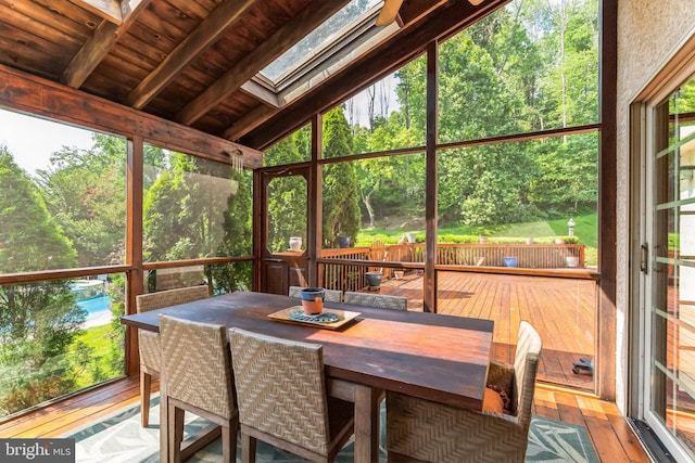 sunroom / solarium with plenty of natural light, lofted ceiling with skylight, and wooden ceiling