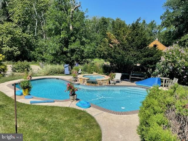 view of pool featuring a lawn and an in ground hot tub