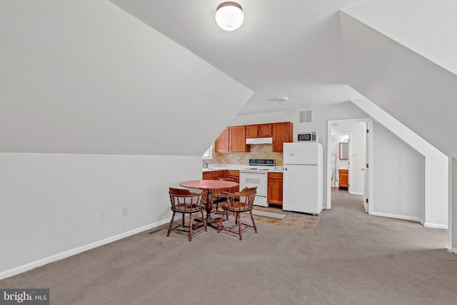 carpeted dining area with lofted ceiling and sink