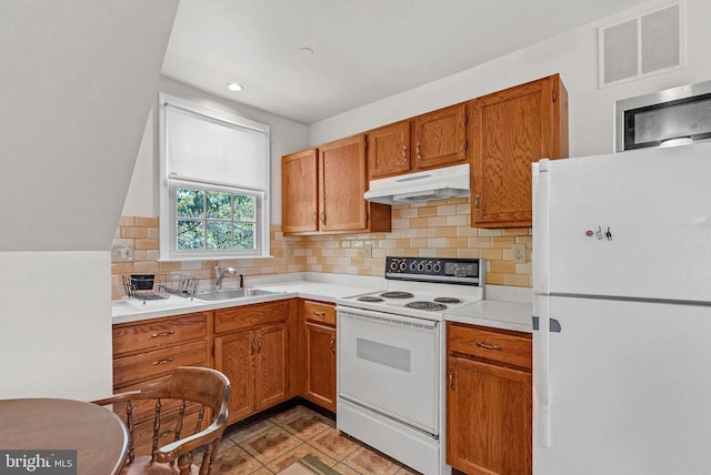 kitchen with decorative backsplash, white appliances, and sink