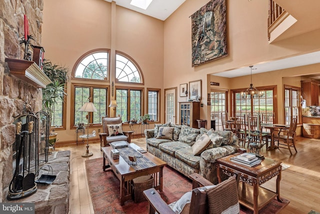 living room with hardwood / wood-style floors, a towering ceiling, and a healthy amount of sunlight