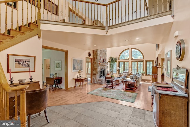 interior space featuring a fireplace, a towering ceiling, and hardwood / wood-style flooring