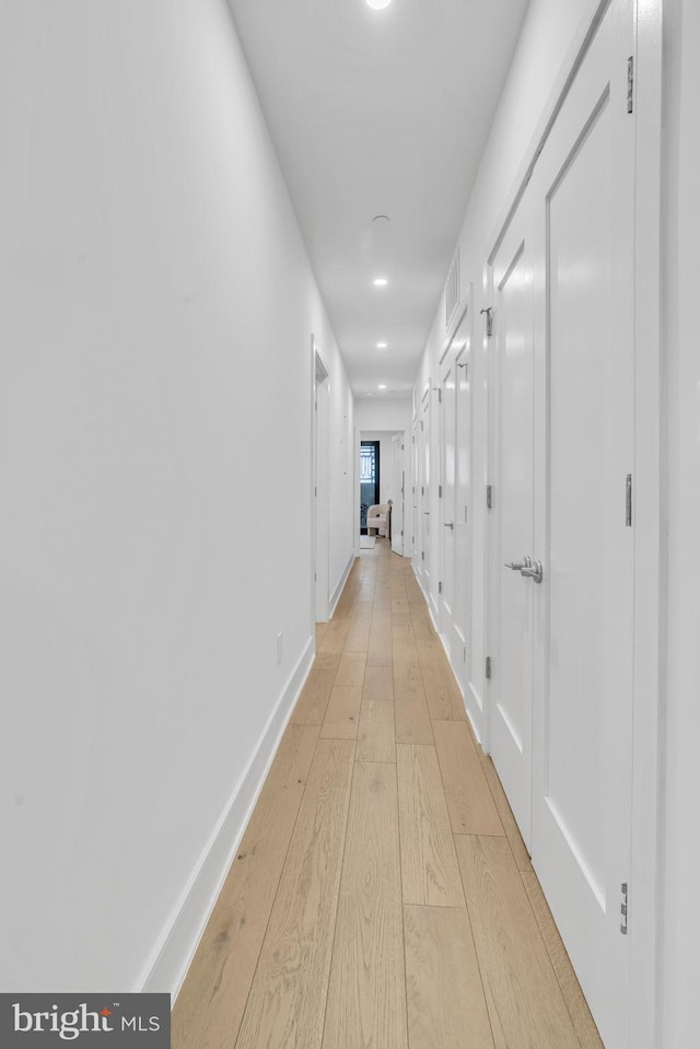 hallway with light hardwood / wood-style floors