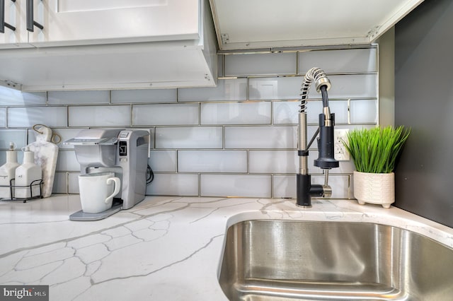 details featuring light stone counters and sink