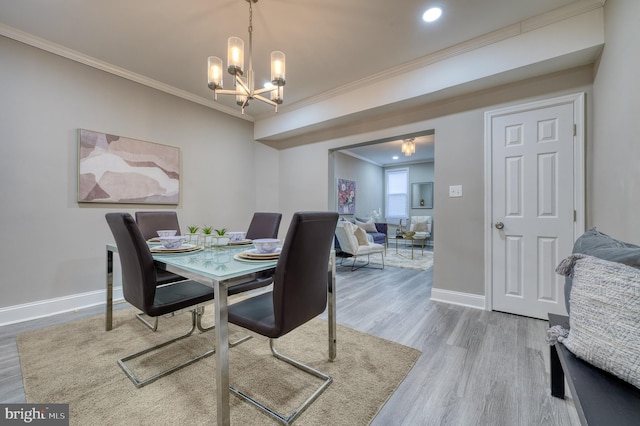 dining room with hardwood / wood-style flooring, an inviting chandelier, and ornamental molding