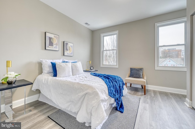 bedroom featuring light hardwood / wood-style floors and multiple windows