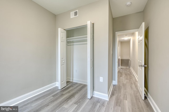 unfurnished bedroom featuring light hardwood / wood-style flooring and a closet