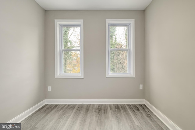 spare room featuring a wealth of natural light and light hardwood / wood-style flooring