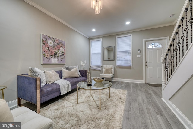 living room featuring hardwood / wood-style flooring, a healthy amount of sunlight, and ornamental molding