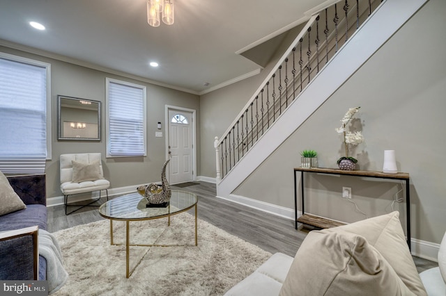 living room with wood-type flooring, a wealth of natural light, and ornamental molding