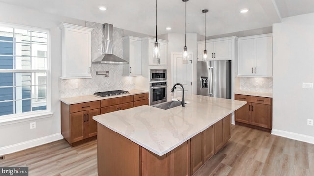 kitchen with sink, white cabinets, stainless steel appliances, and wall chimney range hood