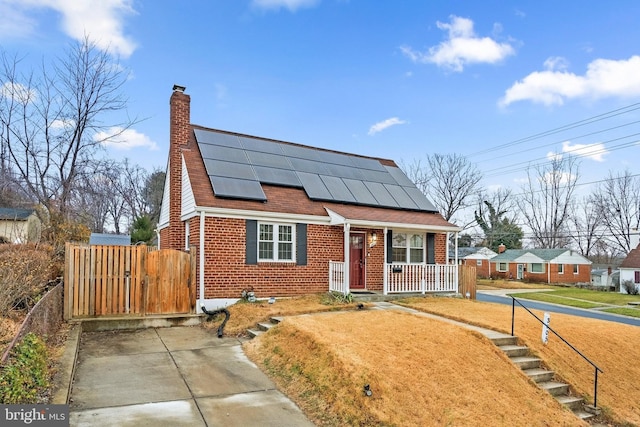 view of front facade featuring solar panels and covered porch