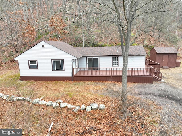 view of front of home with a wooden deck and a storage unit