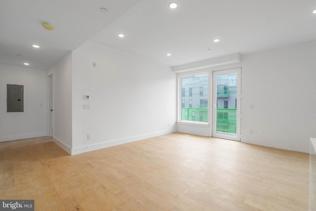 unfurnished room with light wood-type flooring and electric panel