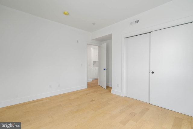 unfurnished bedroom with light hardwood / wood-style floors and a closet