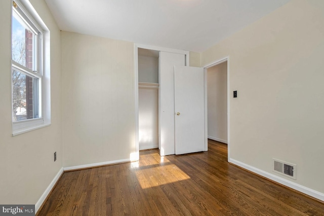 unfurnished bedroom featuring dark hardwood / wood-style floors and a closet