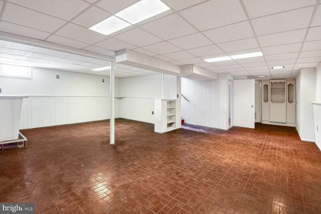 basement with a paneled ceiling