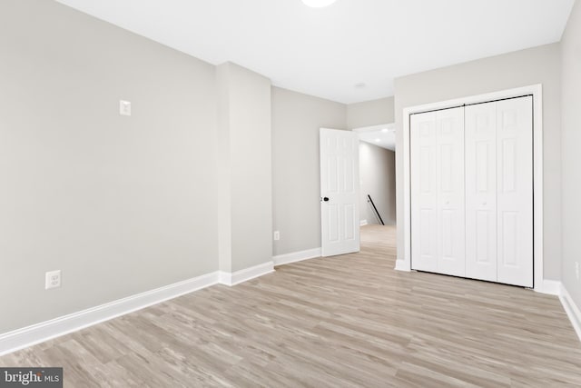 unfurnished bedroom featuring light hardwood / wood-style floors and a closet