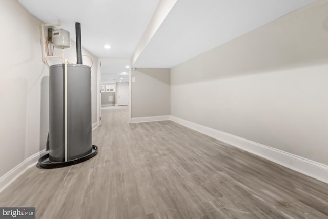 basement featuring gas water heater and wood-type flooring