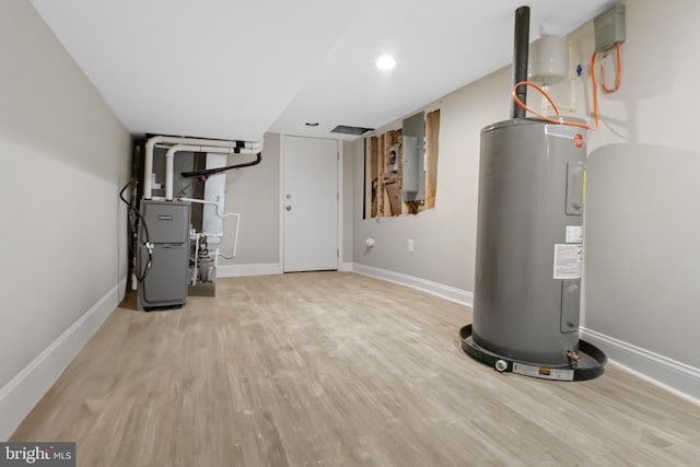 utility room featuring heating unit and water heater