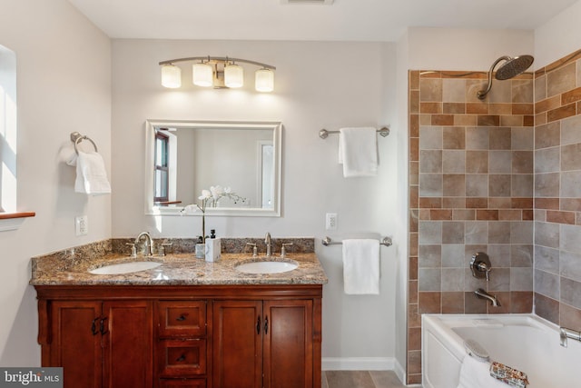 bathroom featuring vanity and tiled shower / bath combo