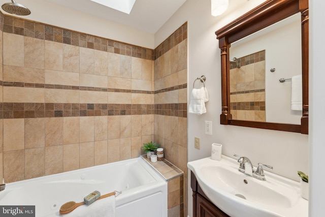 bathroom with vanity, a bath, and a skylight