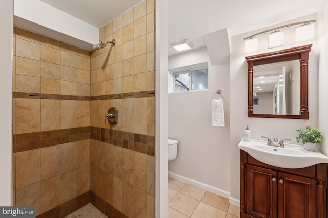 bathroom with vanity, tile patterned floors, toilet, and a tile shower