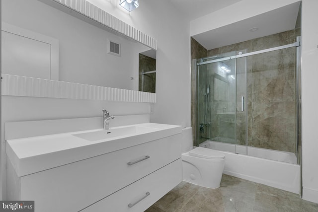 full bathroom featuring vanity, enclosed tub / shower combo, and toilet