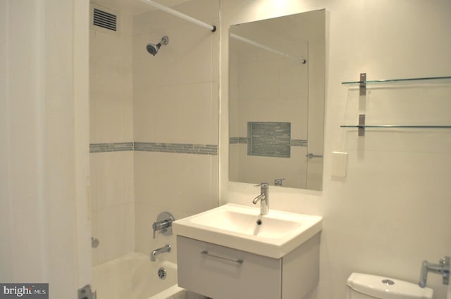 full bathroom featuring vanity, tiled shower / bath combo, and toilet