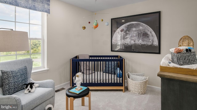 bedroom featuring a crib and carpet