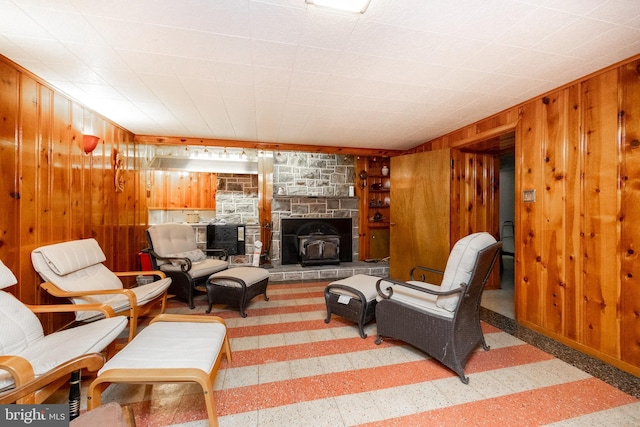 living room featuring a wood stove and wooden walls