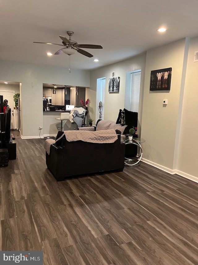 living room with ceiling fan and dark hardwood / wood-style flooring