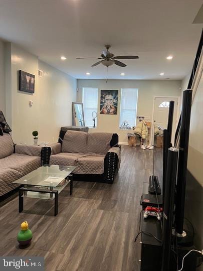 living room with ceiling fan and dark wood-type flooring