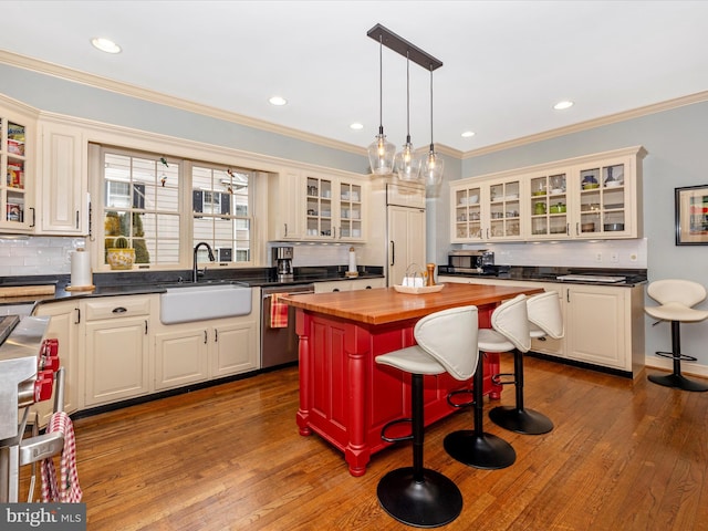 kitchen with stainless steel dishwasher, decorative light fixtures, a kitchen island, a kitchen bar, and butcher block counters