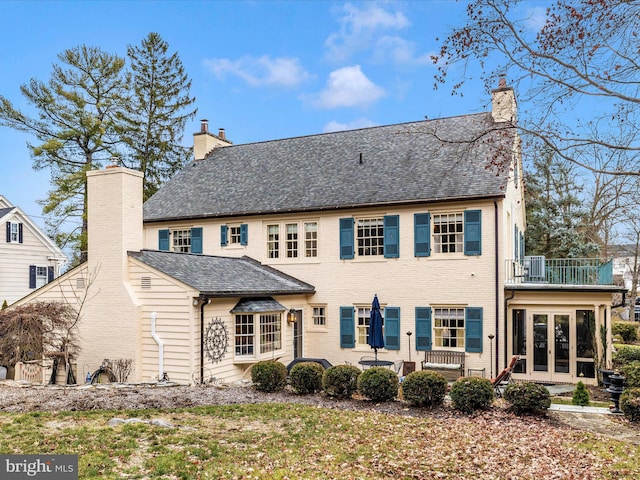 back of house featuring a balcony and french doors