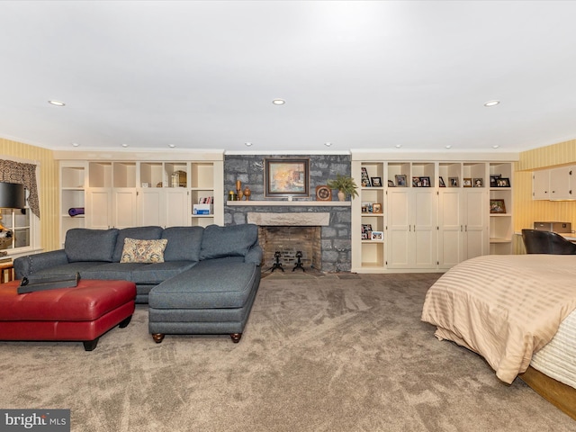 carpeted bedroom featuring a stone fireplace and ornamental molding