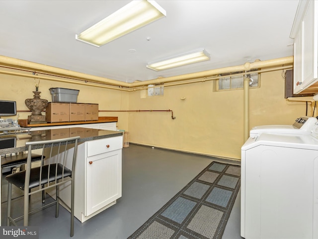 laundry room featuring washer and clothes dryer and cabinets