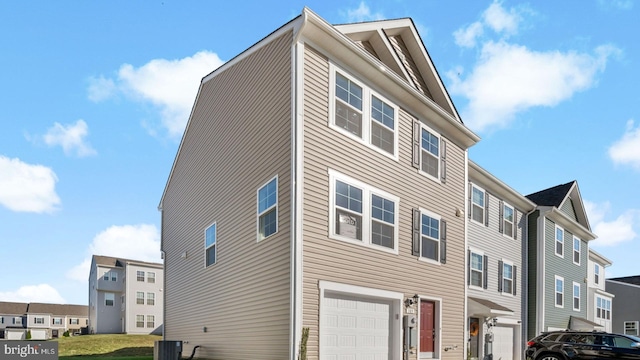 view of side of property featuring central AC unit and a garage