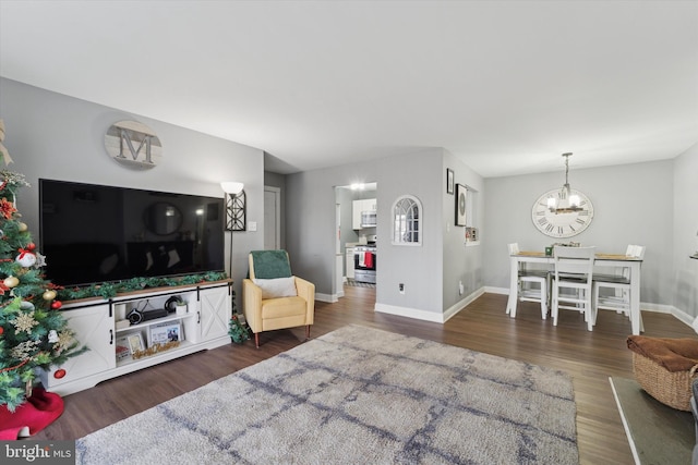 living room featuring dark hardwood / wood-style floors and an inviting chandelier