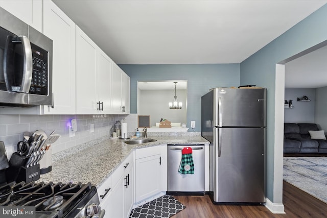 kitchen featuring backsplash, sink, light stone countertops, white cabinetry, and stainless steel appliances