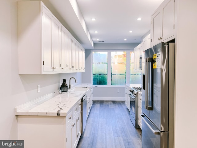 kitchen with dark hardwood / wood-style flooring, white cabinets, stainless steel appliances, and sink