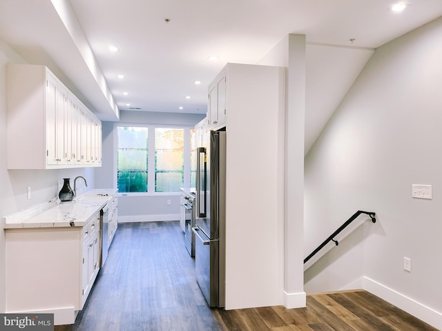 kitchen featuring high end refrigerator, sink, white cabinets, and dark wood-type flooring