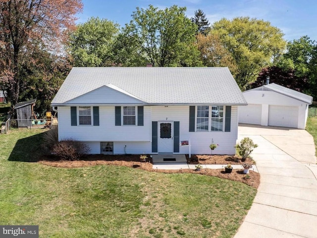 raised ranch with a garage, an outbuilding, and a front yard