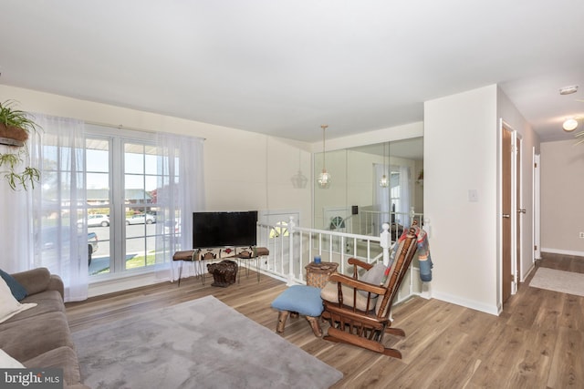 living area with baseboards and wood finished floors